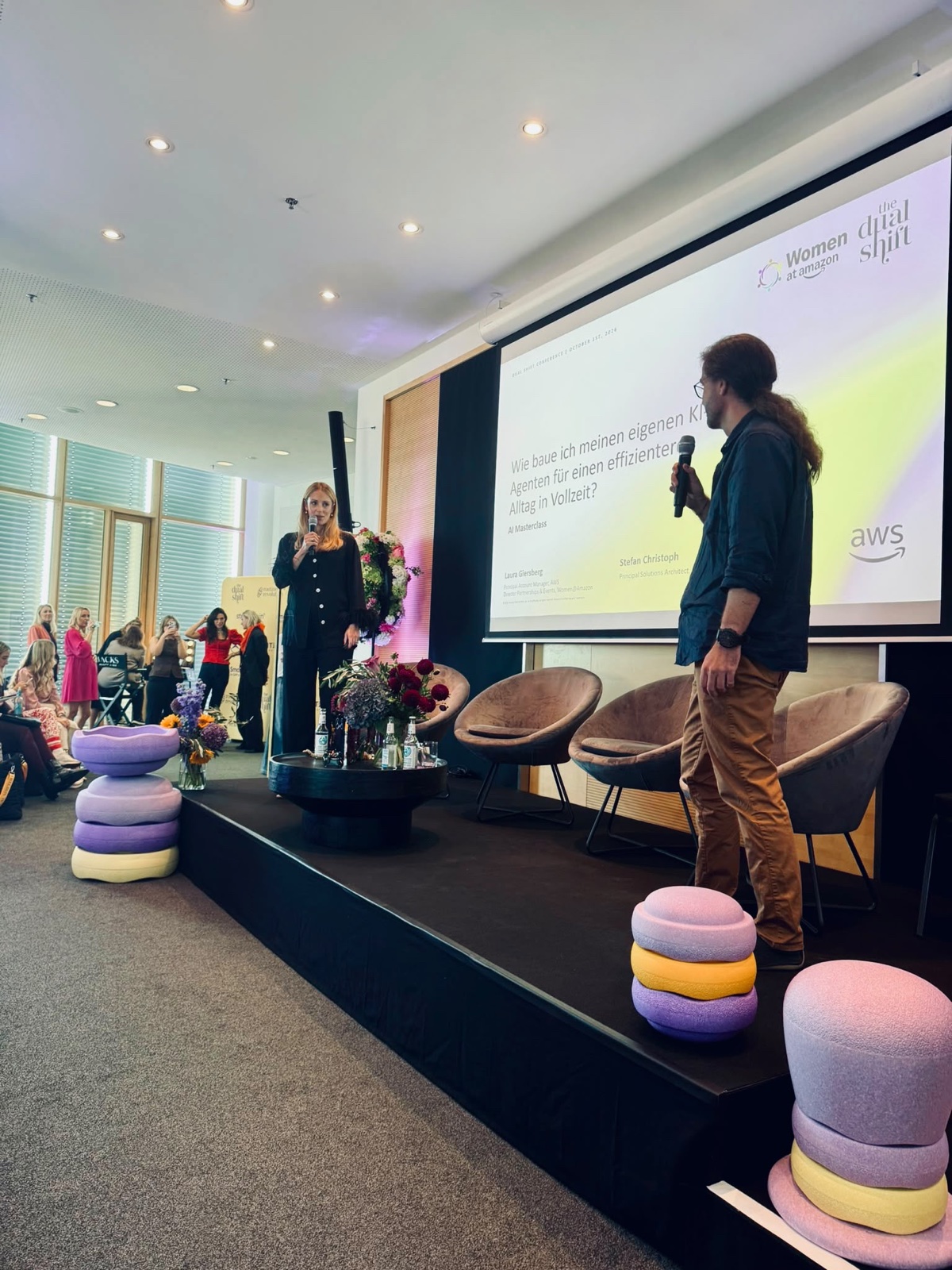 Laura Giersberg and Stefan Christoph on stage at The Dual Shift with the AI Masterclass title slide