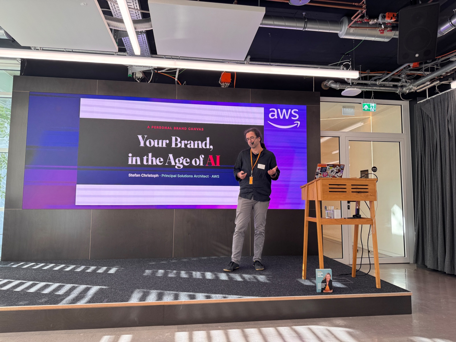 Stefan Christoph on stage in front of a slide reading Your Brand, in the Age of AI